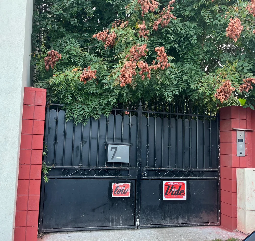 Le portail noir du 7 rue Denis Couturier, encadré de piliers de brique rouge, l'interphone sur la droite.