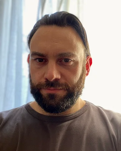 Martin, cheveux tirés en arrière et barbe fournie.